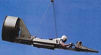 V této stíhačce, zavěšené na ocelovém laně sto metrů nad zemí, leží pilot na břiše. Řízení ovládá rukama a může letět rychlostí až 170 kilometrů za hodinu