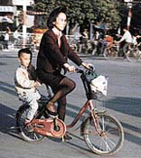 Na kole jezdí v Číně opravdu každý - i elegantní dámy v kostýmku a lodičkách