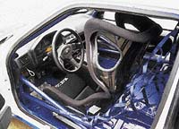 Závodní Peugeot 106 Tomáše Kotka: kontrolka k přeřazení na vyšší rychlost; táhlo vypínající elektrickou soustavu; odlehčené pedály; bezpečnostní sedačka; ochranná síť