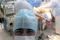 Doktor si odskočil od porodu, aby si vyfotil selfie s rodící mámou za zády