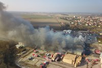 Mohutný požár mrazíren v Mochově pokračuje. V noci hasičům zamrzala technika