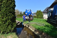 Znečištěný potok v Písnici: Do vody unikla smradlavá kejda, hasiči ji odčerpávají