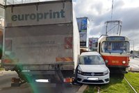 Kuriózní nehoda ve Vysočanech: Auto zůstalo zaklíněné mezi tramvají a náklaďákem, jeden zraněný