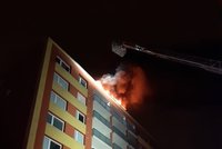 Noční požár paneláku ve Strašnicích: Lidi museli ven z bytů, ze střechy šlehaly plameny
